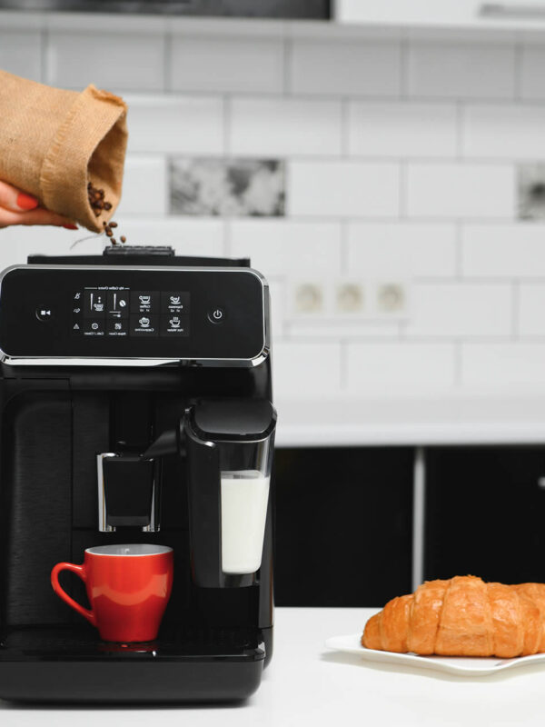Preparació d'una tassa de cafè amb una cafetera elèctrica per a l'esmorzar