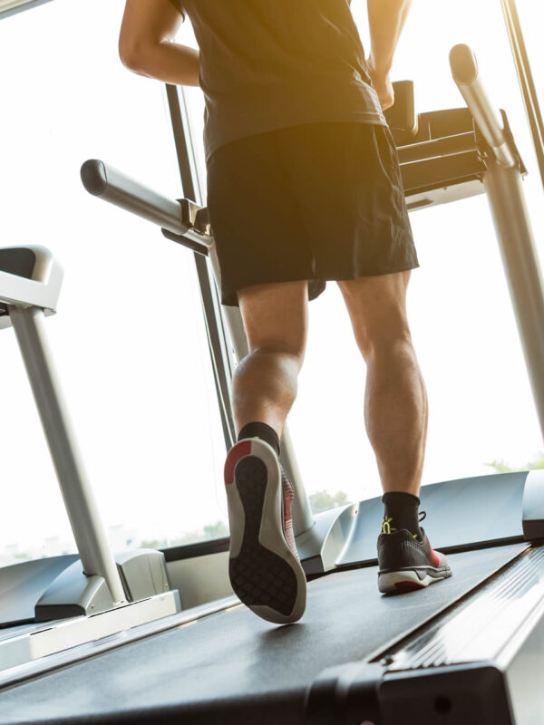 Home entrenant en una cinta de córrer domèstica de la gamma esportiva