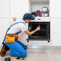 Tècnic de servei instal·lant un forn a la cuina del client.